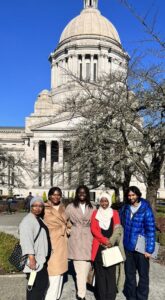 Five women stand in front of the Washington capitol