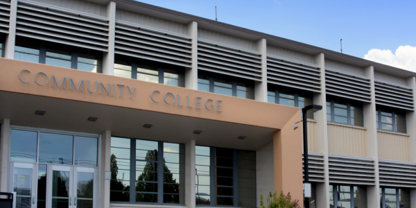 Two story modern building with sign over entrance saying Community College